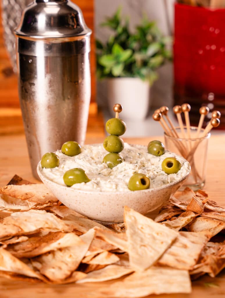 Low carb dirty martini dip with low carb chips on a cutting board
